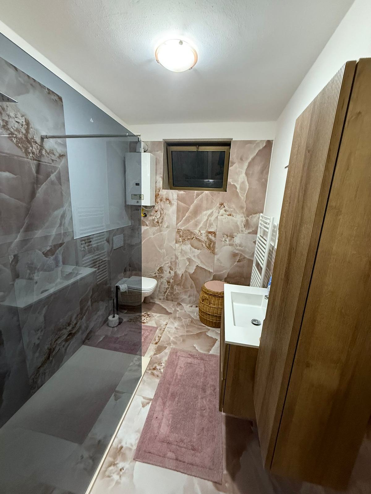 Bagno in onice rosa con doccia walk-in — Ristrutturazione · Lago di Garda